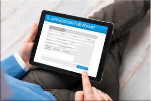 A person filling for a building permit on his tablet.